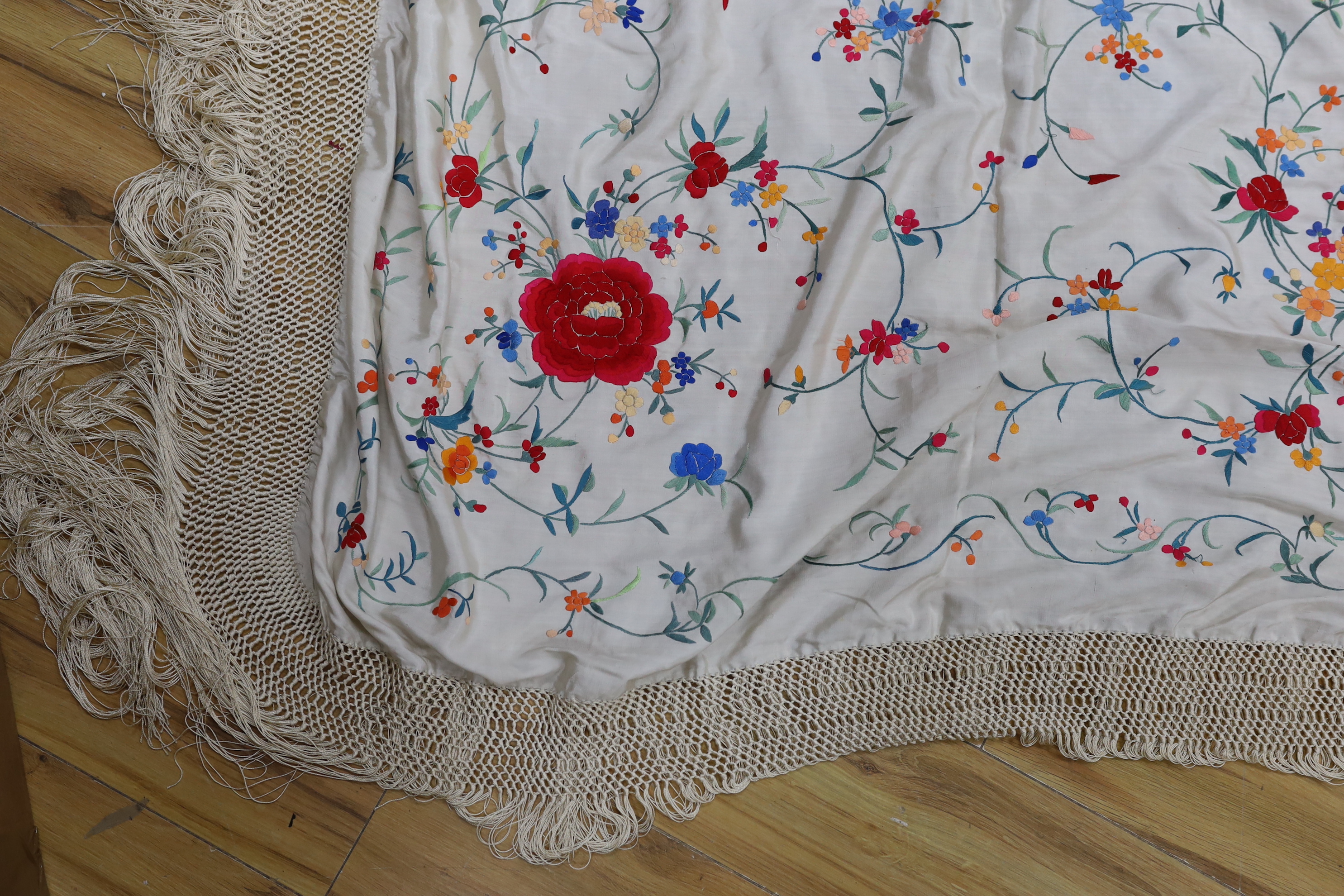 A Chinese cream silk polychrome embroidered shawl